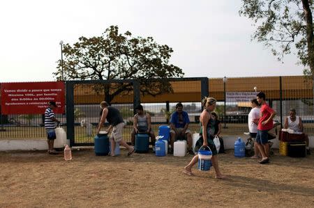 Residents of the region of Sao Paulo state that depends on the Cantareira water system fill water containers from a public tap as the eight-month rationing of water continues as a result of a record drought, in Itu, in this October 18, 2014 file photo. REUTERS/Roosevelt Cassio/Files