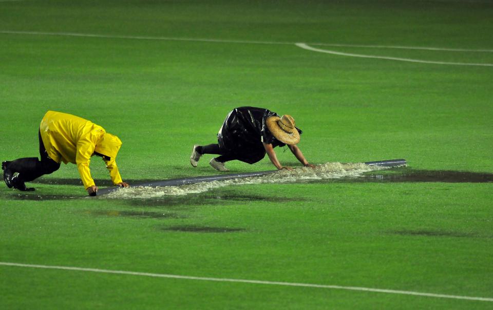 TOPSHOT - Eof Leon football team attempt to clear the water from the field before the Guardianes 2020 tournament football match between Leon and Monterrey, in Leon, Guanajuato state, Mexico on August 3, 2020, amid the Covid-19 novel coronavirus pandemic. (Photo by VICTOR CRUZ / AFP) (Photo by VICTOR CRUZ/AFP via Getty Images)