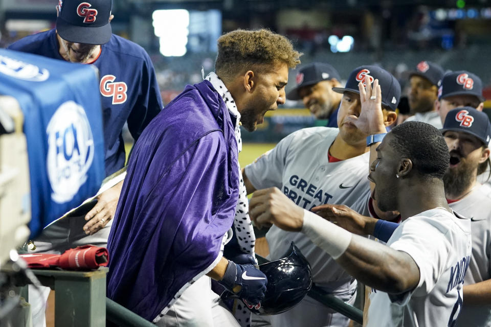 Great Britain's Harry Ford, center, celebrates with teammates in the dugout after hitting a three-run home run against Canada during the fourth inning of a World Baseball Classic game in Phoenix, Sunday, March 12, 2023. (AP Photo/Godofredo A. Vásquez)