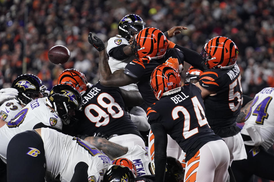 Cincinnati Bengals linebacker Logan Wilson (55) knocks the ball away from Baltimore Ravens quarterback Tyler Huntley causing a fumble in the second half of an NFL wild-card playoff football game in Cincinnati, Sunday, Jan. 15, 2023. Bengals defensive end Sam Hubbard recovered the fumble and ran it back 98-yards for a touchdown. (AP Photo/Jeff Dean)