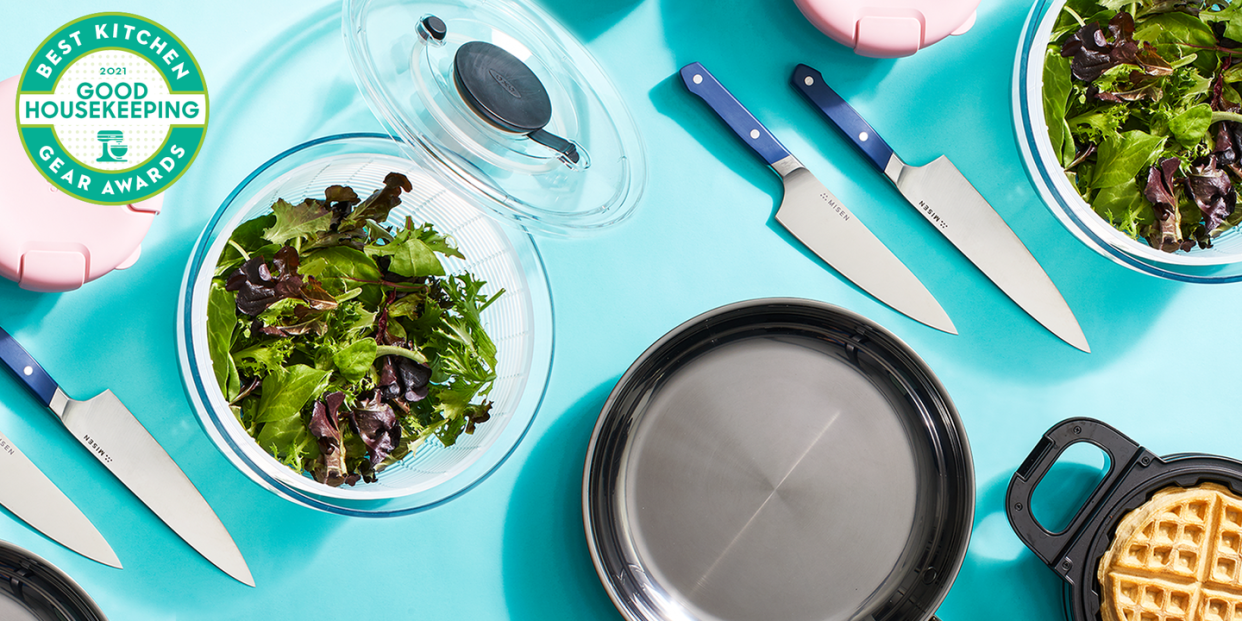 above view shot of kitchen appliances knives, frying pan, salad bowl and waffle maker with good housekeeping kitchen gear awards logo