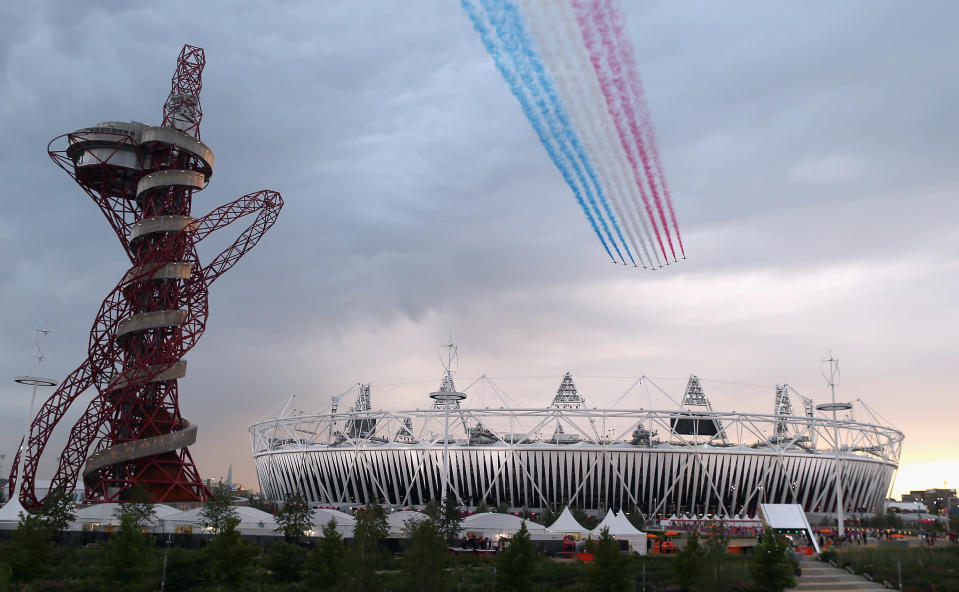 LONDON, ENGLAND - JULY 27: The Red Arrows fly over Olympic Stadium during the Opening Ceremony for the 2012 Summer Olympic Games on July 27, 2012 at Olympic Park in London, England. (Photo by Elsa/Getty Images)