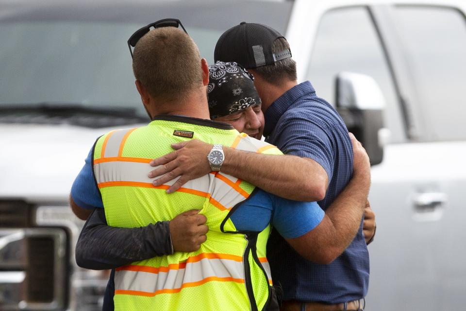 Construction worker Mario Nodal (center) embraces two co-workers after learning his uncle died alongside another worker who died at the site of a trench collapse near North 109th and West Marshall avenues in Phoenix on July 23, 2020. Nodal was working with his uncle and others near the trench when it collapsed.