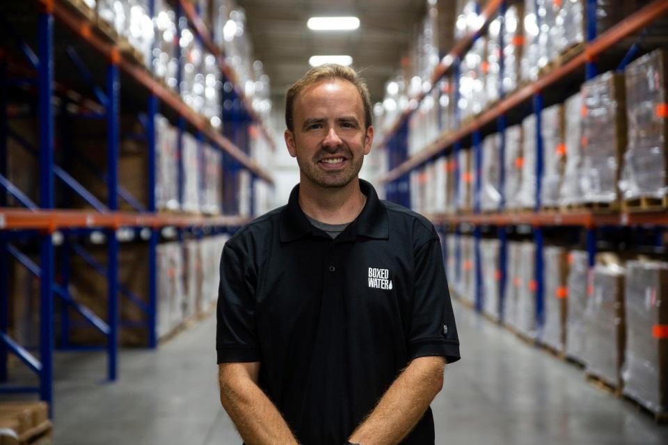 Boxed Water Plant Manager Mike Schwartz stands between the rows of packaged water Friday, Sept. 16, 2023, in Holland, MI.