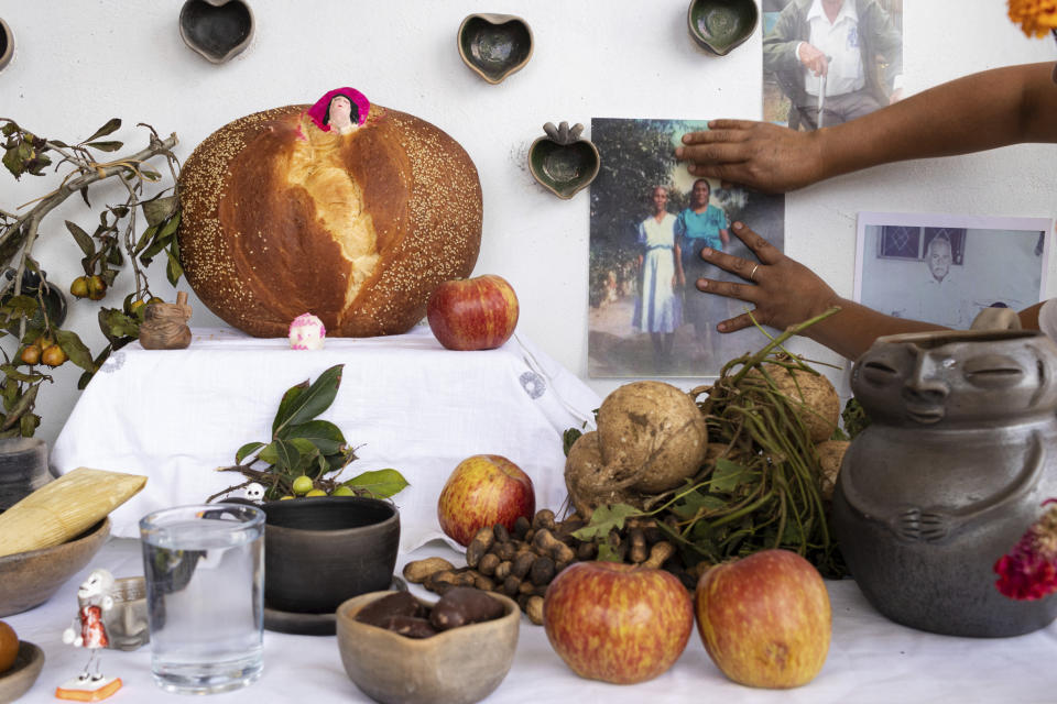 Ana Martínez coloca una foto en su altar del Día de Muertos en la terraza de su casa en Santa María Atzompa, México, el martes 31 de octubre de 2023. (AP Foto/María Alferez)