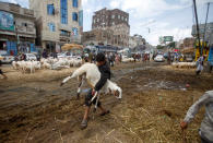 A man carries a sheep at a livestock market ahead of the Eid al-Adha festival amid the coronavirus disease (COVID-19) pandemic in Sanaa, Yemen July 28, 2020. Picture taken July 28, 2020. REUTERS/Mohamed al-Sayaghi TPX IMAGES OF THE DAY