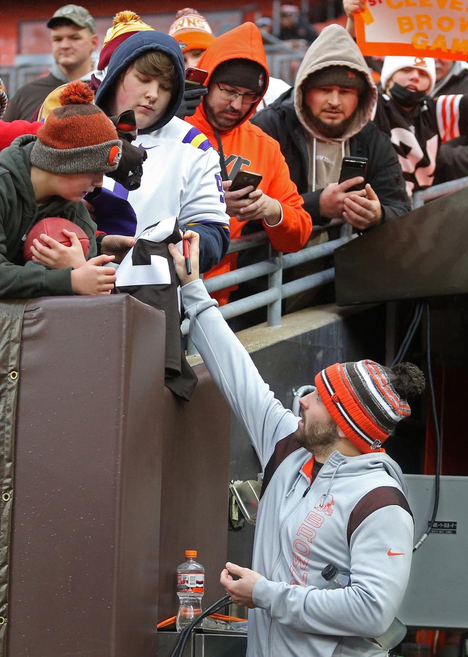 Browns quarterback Baker Mayfield signs autographs for young Browns fans before a game against the Cincinnati Bengals, Sunday, Jan. 9, 2022, in Cleveland.