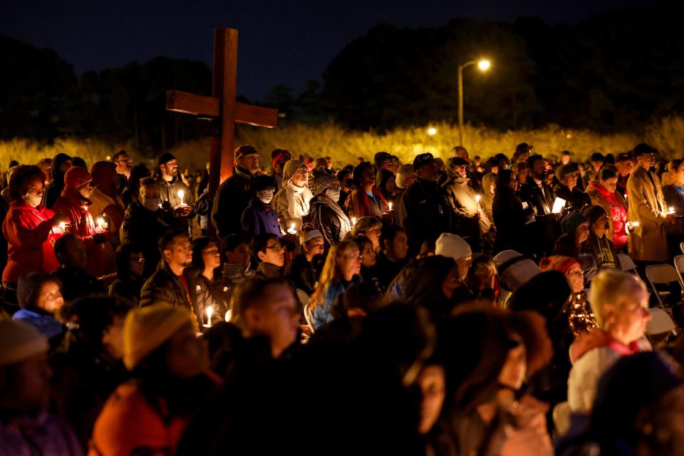 People hold candles as they listen to speakers at a vigil for victims of a shooting at the Chesapeake Walmart Supercenter on November 28, 2022 in Chesapeake, Virginia.