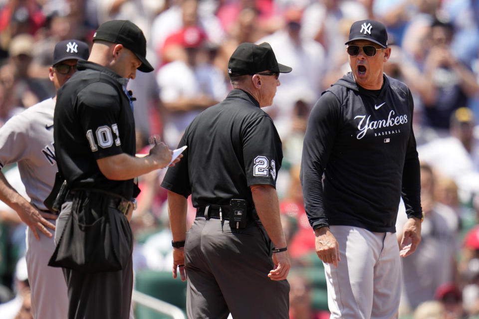 New York Yankees manager Aaron Boone, right, yells after being ejected by home plate umpire Dan Merzel, left, as umpire crew chiefs Lance Barksdale (23) stands between the two during the third inning of a baseball game against the St. Louis Cardinals Sunday, July 2, 2023, in St. Louis. (AP Photo/Jeff Roberson)