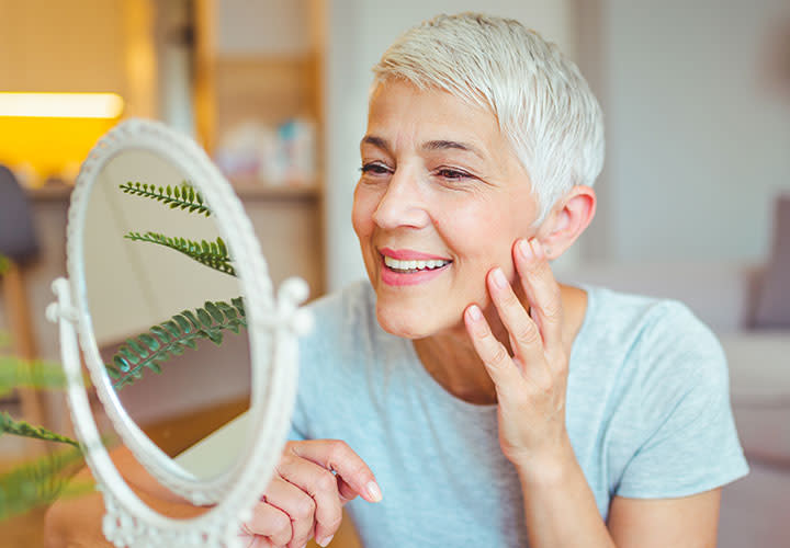 grey-haired-woman-smiling-mirror