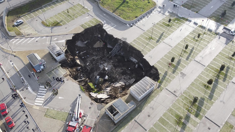 A view of the large sinkhole that opened overnight in the parking of Ospedale del Mare hospital in Naples, Italy, Friday, Jan. 8, 2021. A giant sinkhole opened Friday in the parking lot of a Naples hospital, forcing the temporary closure of a nearby residence for recovering coronavirus patients because the electricity was cut. (Alessandro Pone/LaPresse via AP)