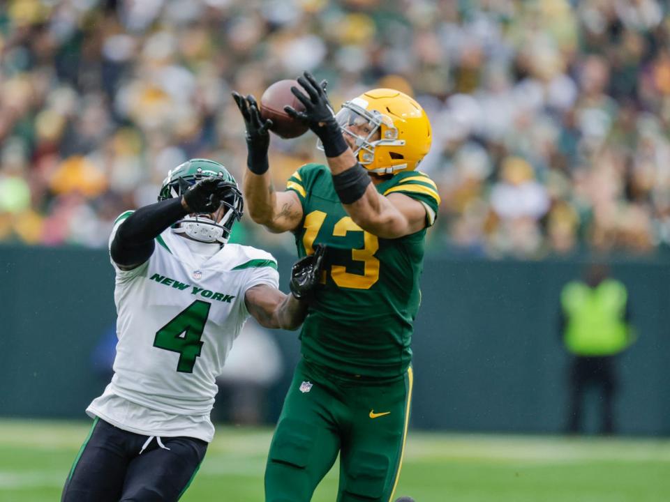 Allen Lazard makes a catch over a Jets defender during a game.