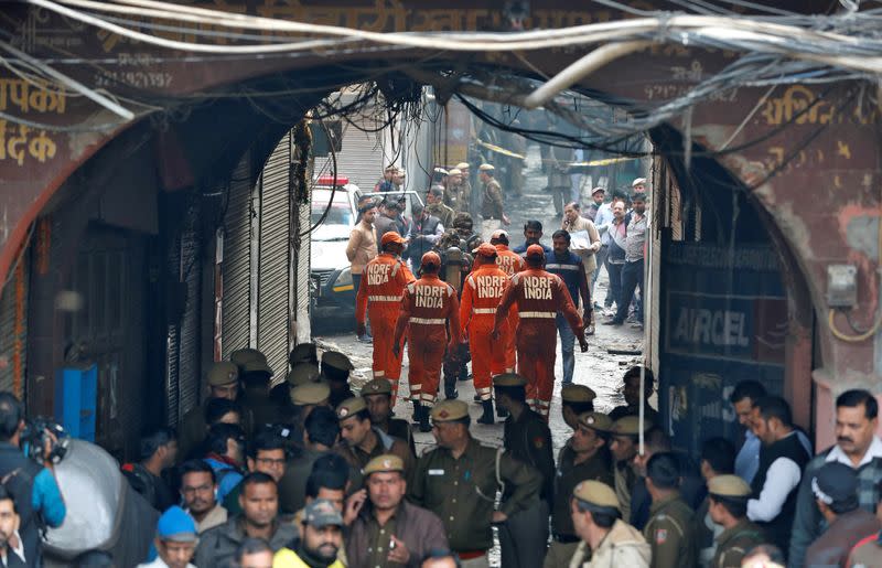 Members of NDRF head towards the site of a fire that swept through a factory where laborers were sleeping, in New Delhi