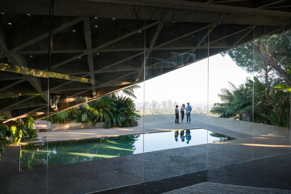 Three people stand in the distance, near a pool.