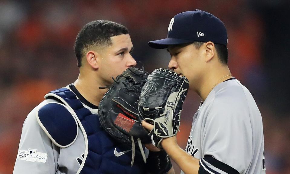 Masahiro Tanaka #19 talks to Gary Sanchez #24 of the New York Yankees on the mound after giving up two runs in the fourth inning against the Houston Astros during game one of the American League Championship Series at Minute Maid Park on October 13, 2017 in Houston, Texas.