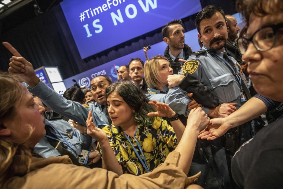 Manifestantes chocan con empleados de seguridad durante una protesta en la cumbre COP25 en Madrid, el miércoles 11 de diciembre de 2019. (AP Foto/Bernat Armangue)