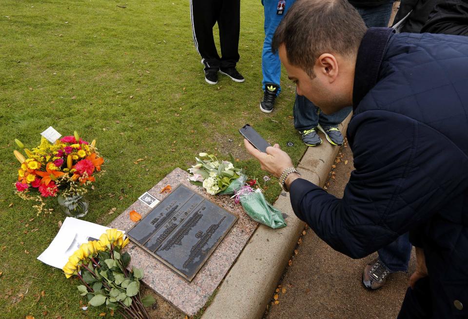 Kadar of Kurdistan takes a picture of JFK assassination historic landmark plaque in Dallas's Dealey Plaza at the spot where U.S. President John F. Kennedy was assassinated in 1963 in Dallas