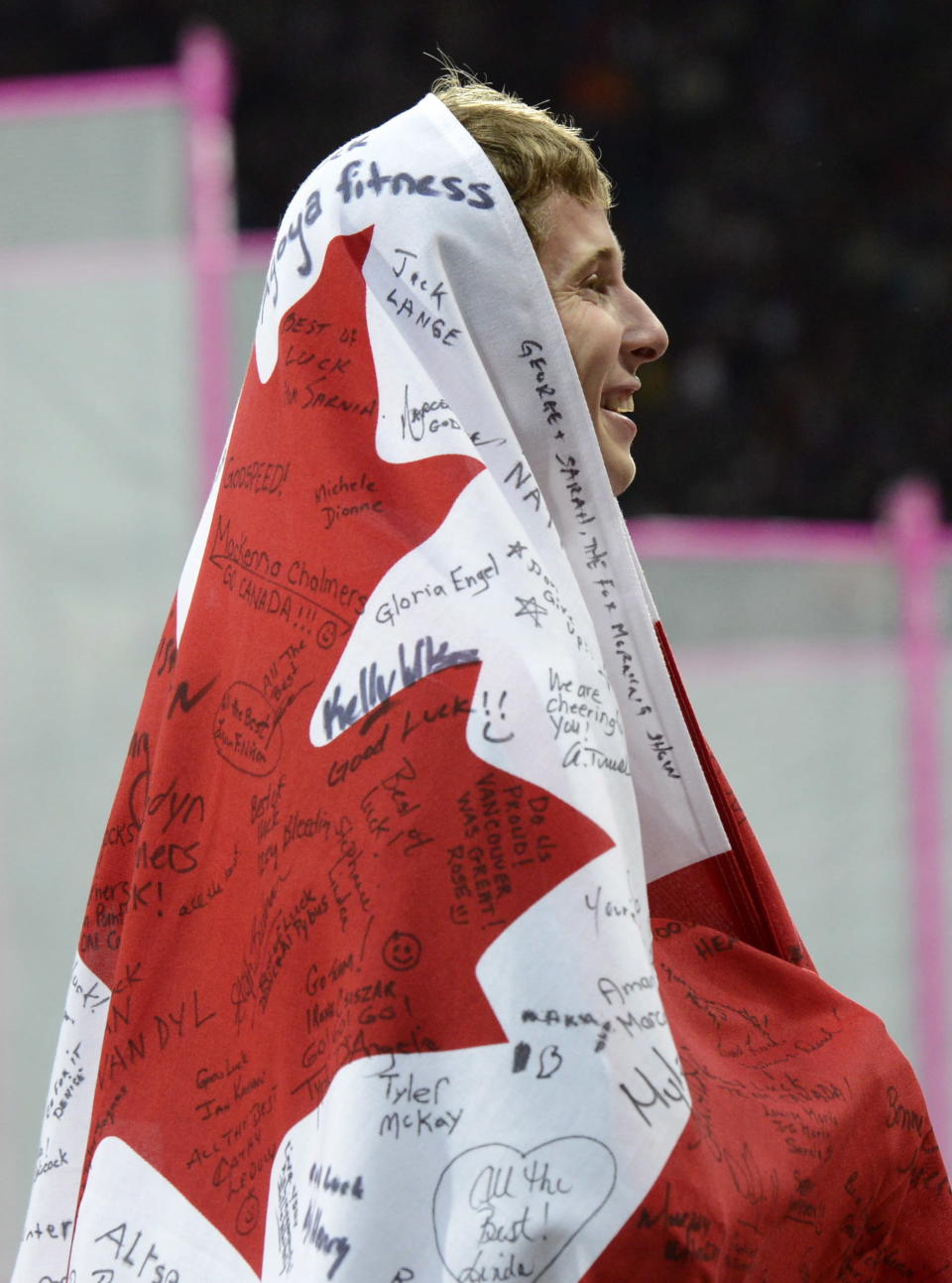 Canada's Derek Drouin wraps himself in the Canada flag as he celebrates his bronze in the men's high jump finals at the Olympic Stadium during the Summer Olympics in London on Tuesday, August 7, 2012. THE CANADIAN PRESS/Sean Kilpatrick
