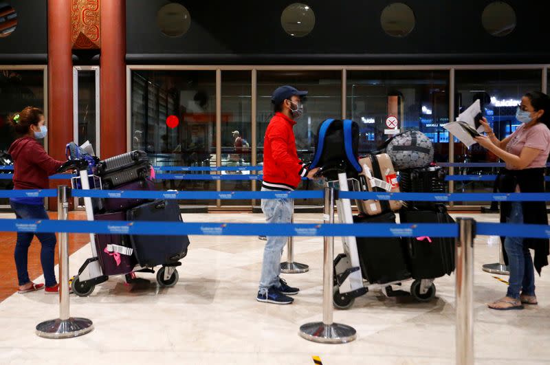 Passengers stand in a line to have their temperature and oxygen level checked before boarding flights at Soekarno Hatta Airport amid the coronavirus disease (COVID-19) outbreak in Jakarta