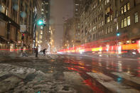 <p>In a photo taken with a long exposure, vehicles pass as pedestrians cross Fifth Avenue in midtown Manhattan during a storm in New York City on March 7, 2018. (Photo: Gordon Donovan/Yahoo News) </p>