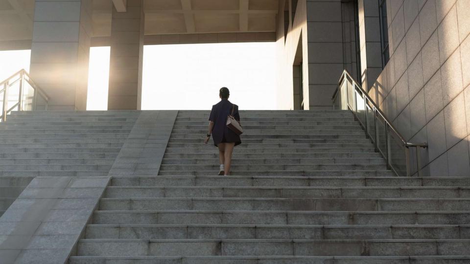 PHOTO: A woman walks up stairs in sunlight. (STOCK PHOTO/Getty Images)