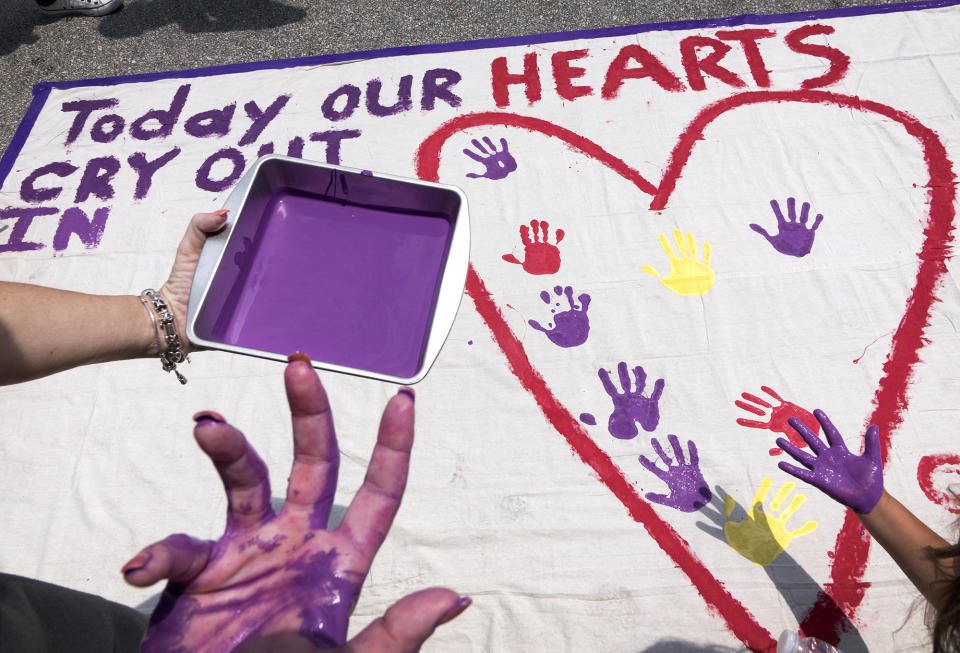 <p>People stamp their painted hands on a banner made by Chicago artist Greg Marchuk, in supporting of the victims of the shooting at the Pulse nightclub in Orlando, Fla., June 12, 2016. (EPA/Cristobal Herrera) </p>