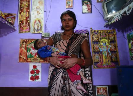 Five-year-old Saagar, who suffers from mental and physical disabilities is held by his mother Komal, as she poses for a picture at their house in a slum in Bhopal November 12, 2014. REUTERS/Danish Siddiqui