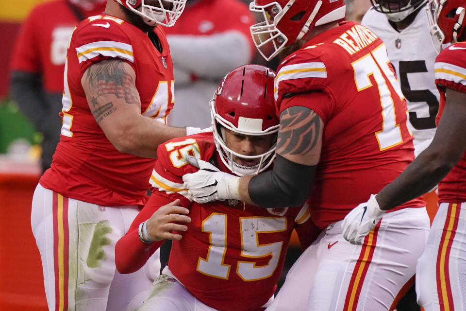 Kansas City Chiefs quarterback Patrick Mahomes (15) is helped off the field by teammate Mike Remmers, right, after getting injured during the second half of an NFL divisional round football game against the Cleveland Browns, Sunday, Jan. 17, 2021, in Kansas City. (AP Photo/Charlie Riedel)