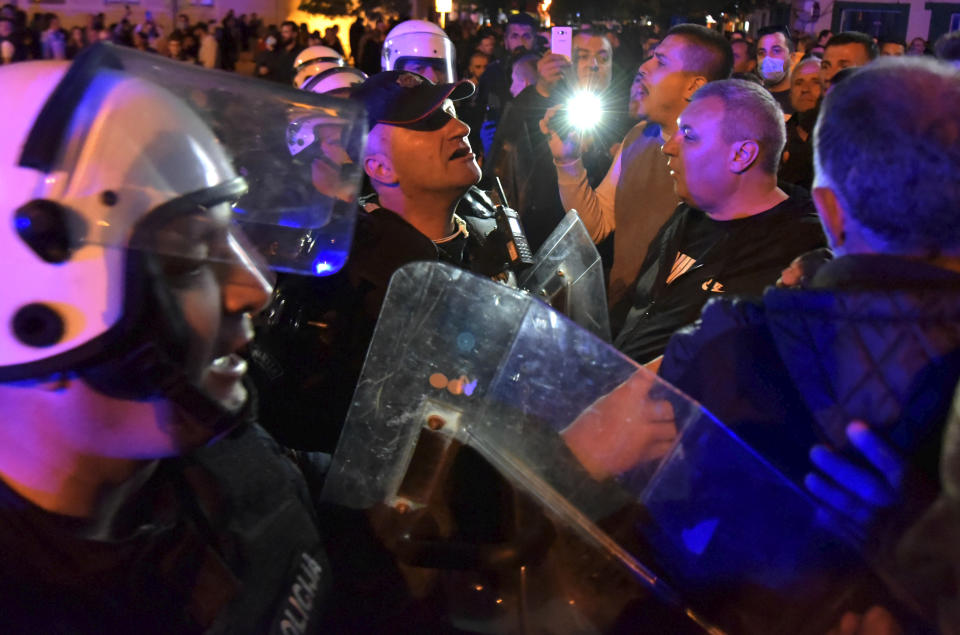 Montenegrin police officers block the street during a protest in Niksic, Montenegro, Wednesday, May 13, 2020. Montenegrin police used tear gas to disperse protests demanding the release of eight Serbian Orthodox Church priests who were detained for organizing a religious procession despite a ban on gatherings because of the coronavirus. (AP Photo/Risto Bozovic)