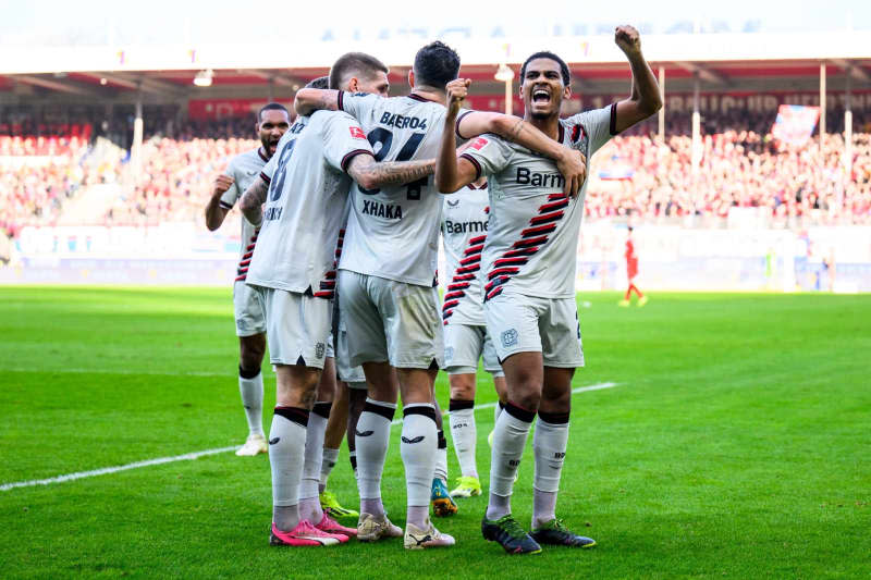 Leverkusen's Jeremie Frimpong celebrates scoring his side's first goal with teammates during the German Bundesliga soccer match between 1. FC Heidenheim and Bayer Leverkusen at the Voith-Arena. Tom Weller/dpa