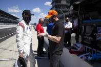 FILE - In this image provided by Jimmie Johnson Racing II, Inc., seven-time NASCAR champion Jimmie Johnson, left, listens to a crew member during IndyCar during testing with Chip Ganassi Racing on the road course at Indianapolis Motor Speedway, Tuesday, July 28, 2020, in Indianapolis. Jimmie Johnson will transition from NASCAR to IndyCar with Chip Ganassi Racing in a partnership that could pair two of the most dominant drivers of this generation on one team. The seven-time NASCAR champion will work with the Ganassi organization to finalize sponsorship on a two-year program for Johnson to run the road and street course races on IndyCar's schedule. If funding is secured, Johnson would be teammates with five-time IndyCar champion Scott Dixon. (Jimmie Johnson Racing II, Inc. via AP, File)