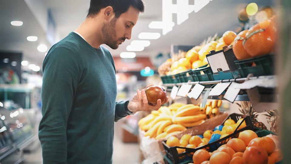 man buying fruit in supermarket