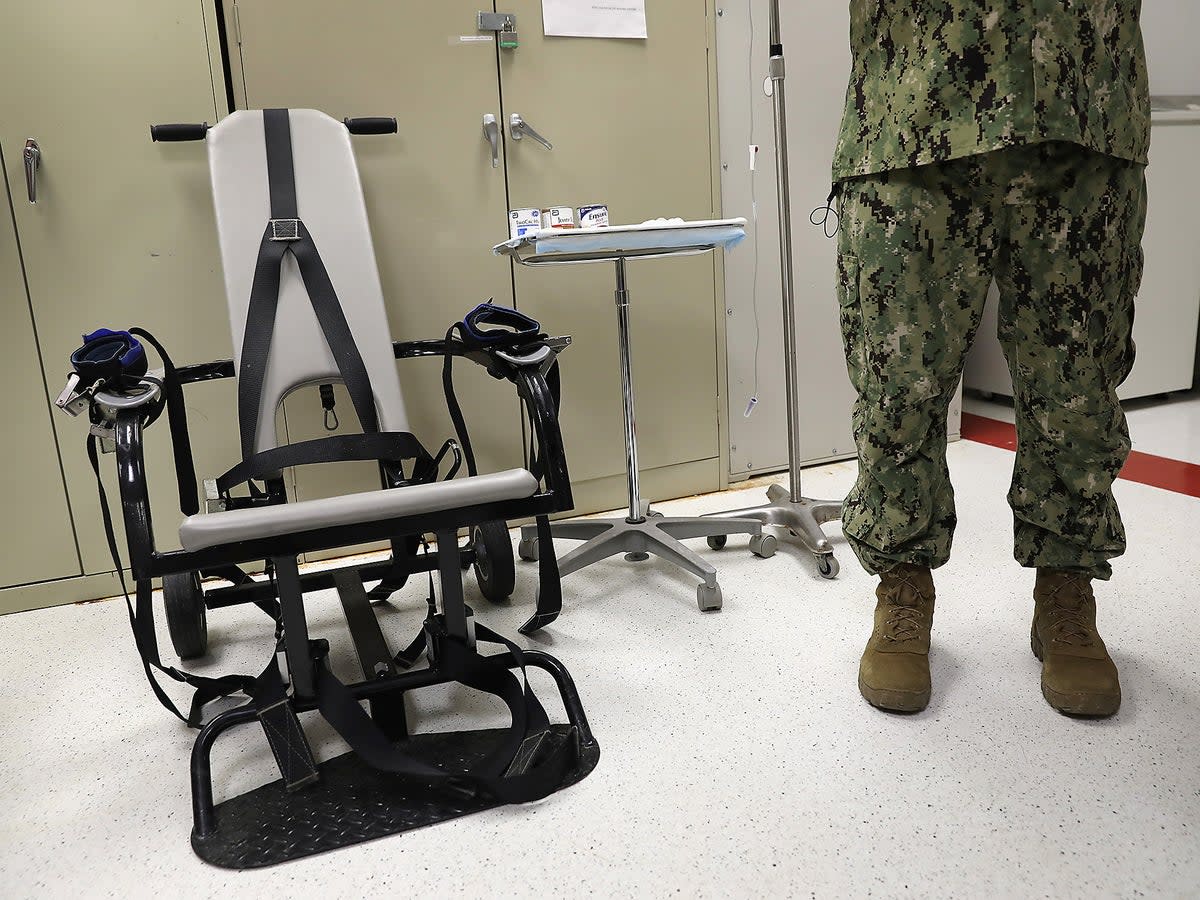 A US Navy doctor displays a restraint chair in the detainee clinic in the ‘Gitmo’ maximum security detention center at the US Naval Station at Guantanamo Bay, Cuba (Getty)