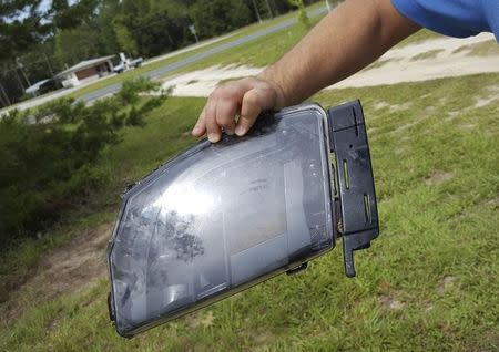 Robert VanKavelaar shows a piece of the Tesla found in his property where the Tesla came to rest when its driver was killed in a collision with a truck in May in Williston, Florida, U.S. July 1, 2016. REUTERS/Barbara Liston