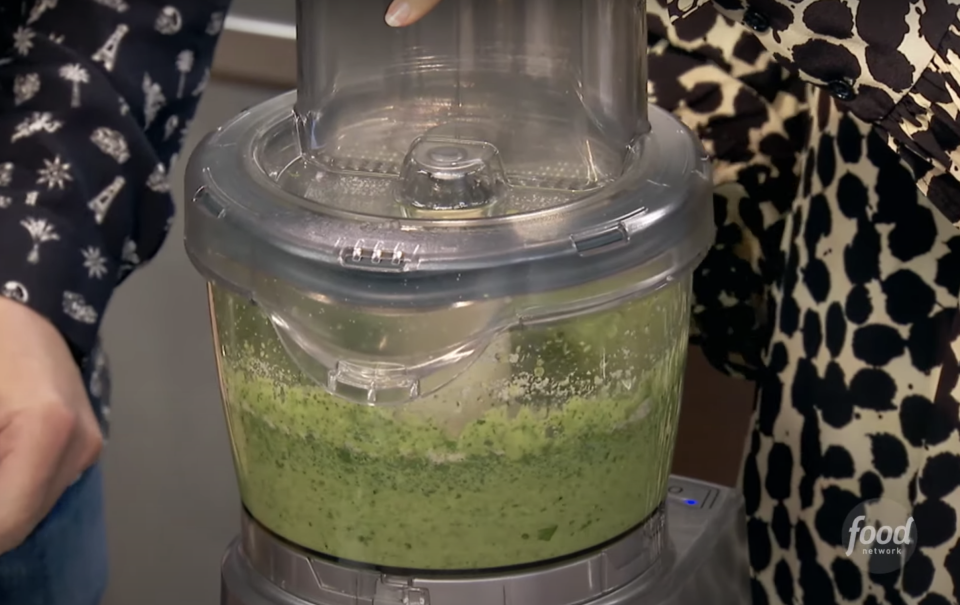 someone making pesto in a food processor