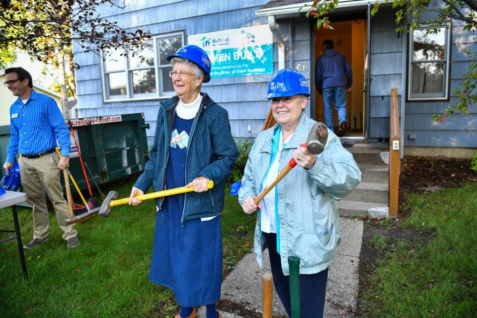 Sister Dorothy Manuel and Sister Karen Streveler pose for photographs with sledgehammers during a kick-off event at a new Habitat for Humanity project house Tuesday in St. Joseph, Minn.. The house was donated to Habitat for Humanity by Sisters of the Order of St. Benedict.