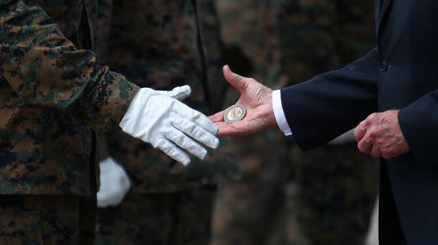 U.S. President Joe Biden hands challenge coins to members of the U.S. Marine Corps Honor Guard before boarding Air Force One at Dover Air Force Base in Dover, Delaware, U.S.