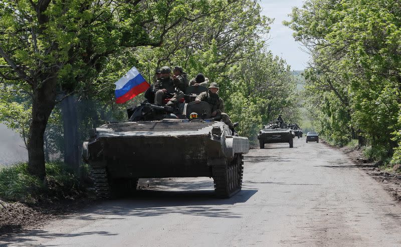 A convoy of Russian armoured vehicles drives along a road near Mariupol