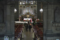 Devotees wearing protective face masks amid the new coronavirus pandemic, walk into the San Hipolito Catholic church during the annual pilgrimage honoring Saint Jude, the patron saint of lost causes, in Mexico City, Wednesday, Oct. 28, 2020. Thousands of Mexicans did not miss this year to mark St. Jude's feast day, but the pandemic caused Masses to be canceled and the rivers of people of other years were replaced by orderly lines of masked worshipers waiting their turn for a blessing. (AP Photo/Marco Ugarte)