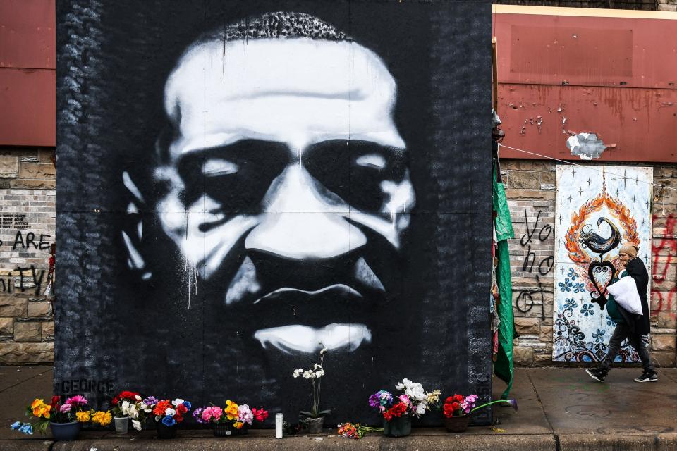 A woman walks near the makeshift memorial of George Floyd before the third day of jury selection begins in the trial of former Minneapolis Police officer Derek Chauvin who is accused of killing Floyd, in Minneapolis, Minnesota on March 10, 2021. (Photo by CHANDAN KHANNA / AFP) (Photo by CHANDAN KHANNA/AFP via Getty Images)