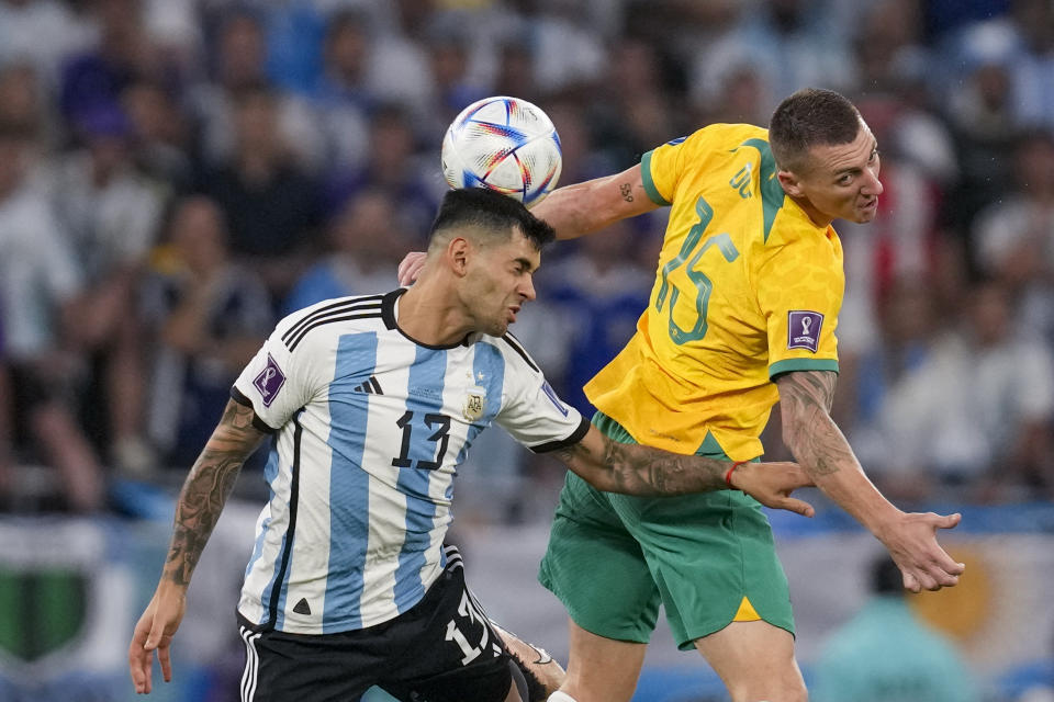 El argentino Cristian Romero (izquierdo) y el australiano Mitchell Duke pugnan por el balón durante el partido por los octavos de final del Mundial, el sábado 3 de diciembre de 2022, en Rayán, Qatar. (AP Foto/Thanassis Stavrakis)