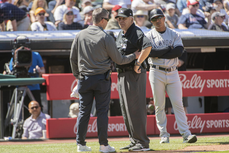 Umpire Larry Vanover is attended to by a Cleveland Guardians trainer after being hit by a throw from the outfield during the fifth inning of a baseball game in Cleveland, Wednesday April 12, 2023. Vanover left the game because of the injury. (AP Photo/Phil Long)