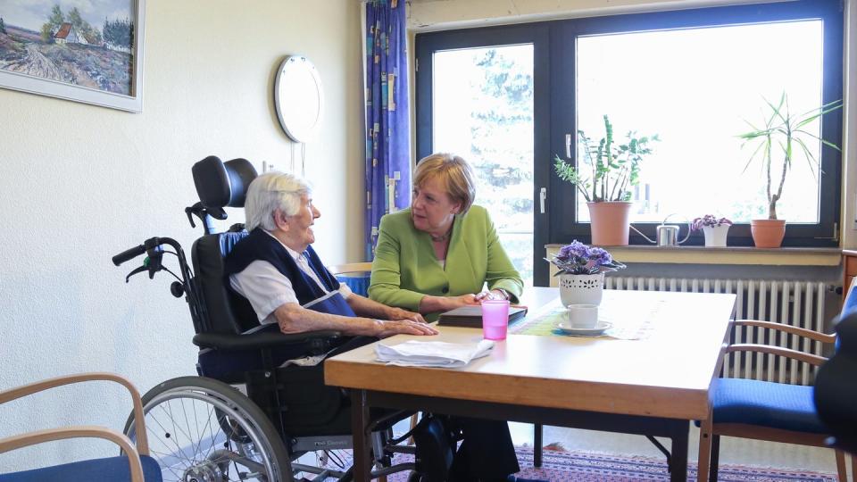 Bundeskanzlerin Angela Merkel besucht das Altenheim St. Johannisstift in Paderborn und spricht mit einer Bewohnerin. Foto: Friso Gentsch