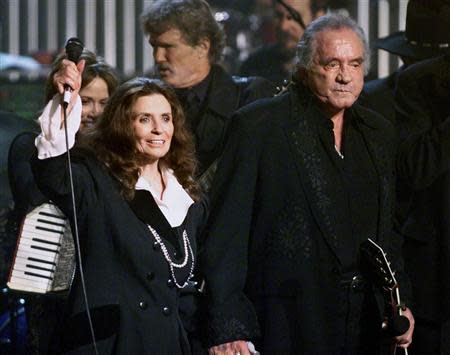 Country music singer-songwriter Johnny Cash and his wife June Carter Cash wave to fans at the end of a tribute in his honor in New York in this file photo taken April 6, 1999. REUTERS/Jeff Christensen/Files