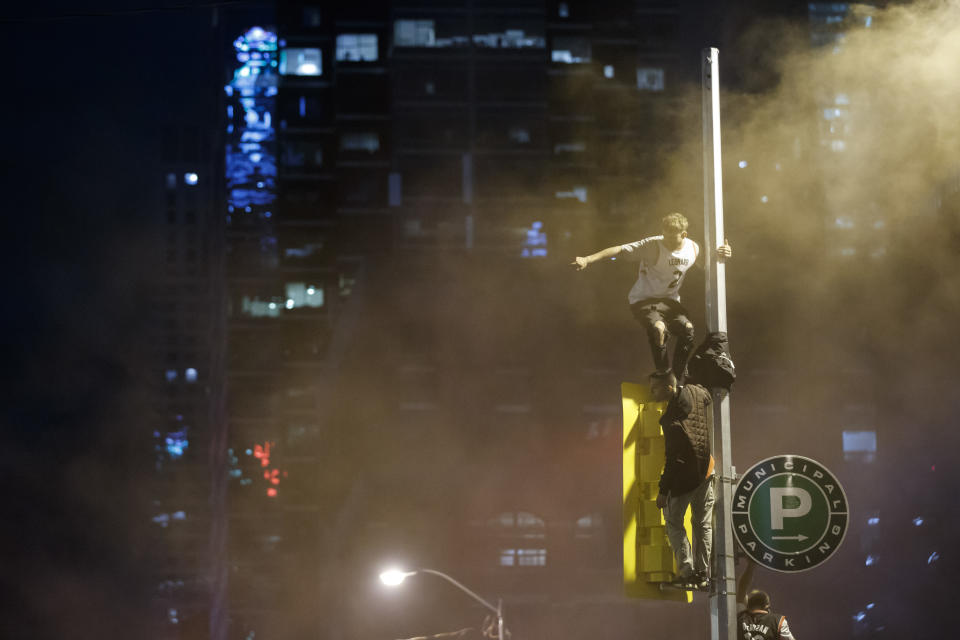 TORONTO, ON - JUNE 13: People celebrate by hanging on a telephone pole as they celebrate a victory over the Golden State Warriors in game six of the NBA Finals on June 13, 2019 in Toronto, Canada. (Photo by Cole Burston/Getty Images)