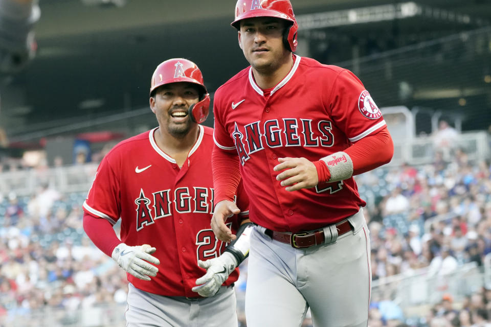 Los Angeles Angels' Kurt Suzuki, left, and Jose Iglesia head to the dugout following a two-run home run by Suzuki off Minnesota Twins pitcher J.A. Happ during the first inning of a baseball game Friday, July 23, 2021, in Minneapolis. (AP Photo/Jim Mone)