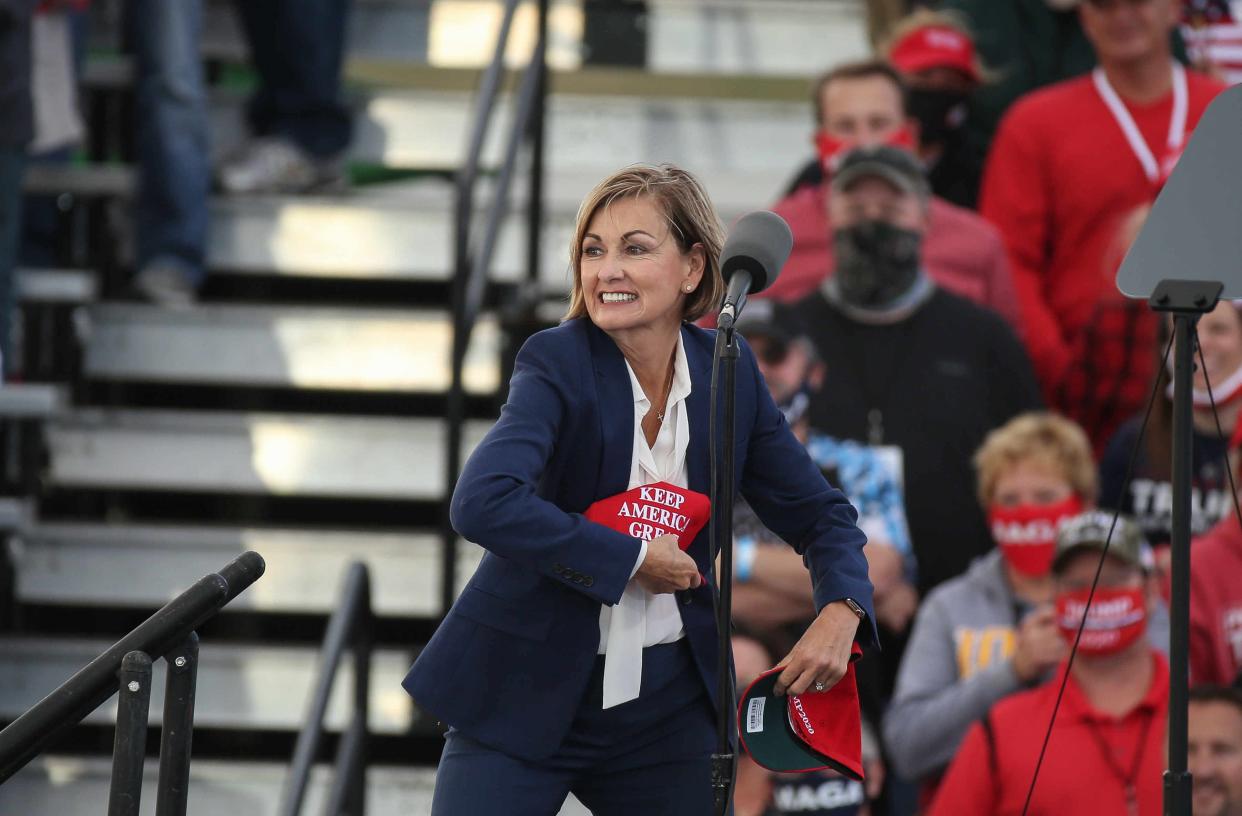 Iowa Gov. Kim Reynolds tosses Keep America Great hats prior to the arrival of U.S. President Donald Trump at the Des Moines International Airport during a rally in Iowa on Wednesday, Oct. 14, 2020.