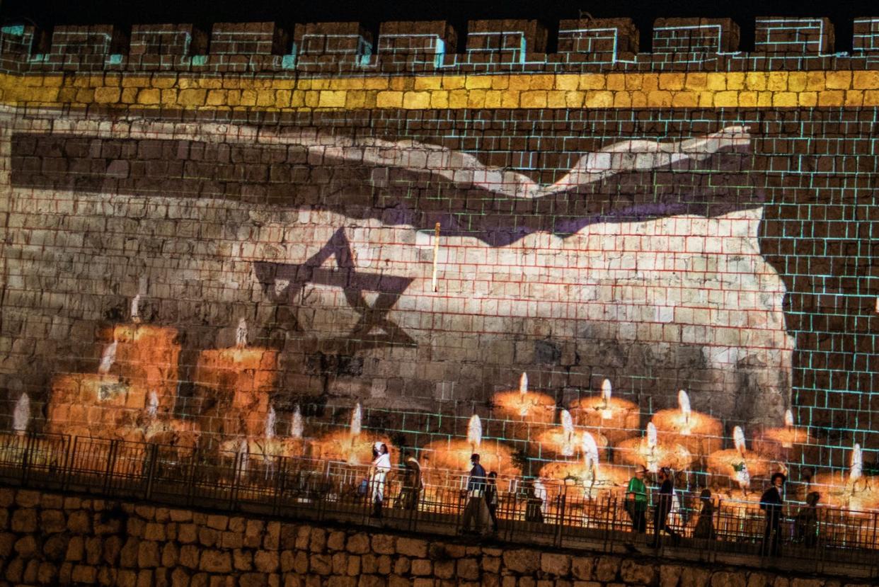 <span class="caption">A condolence message and candles for the victims of a stampede during a Jewish ultra-Orthodox mass pilgrimage to Mount Meron, projected on a wall of Jerusalem's Old City.</span> <span class="attribution"><a class="link " href="https://www.gettyimages.com/detail/news-photo/may-2021-israel-jerusalem-a-condolence-message-and-candles-news-photo/1232635524?adppopup=true" rel="nofollow noopener" target="_blank" data-ylk="slk:Ilia Yefimovich/picture alliance via Getty Images;elm:context_link;itc:0;sec:content-canvas">Ilia Yefimovich/picture alliance via Getty Images</a></span>