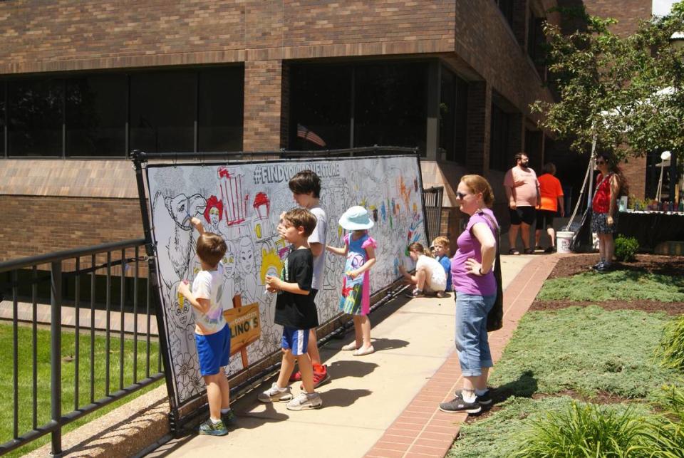 Children contribute to a mural during Art on the Square in downtown Belleville Saturday.