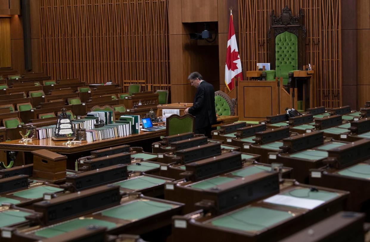 A House of Commons clerk is seen in the House of Commons chamber. After a flurry of activity late into the evening Wednesday, MPs cleared the legislative decks and passed some key government bills before a three-month summer recess.  (Adrian Wyld/Canadian Press - image credit)